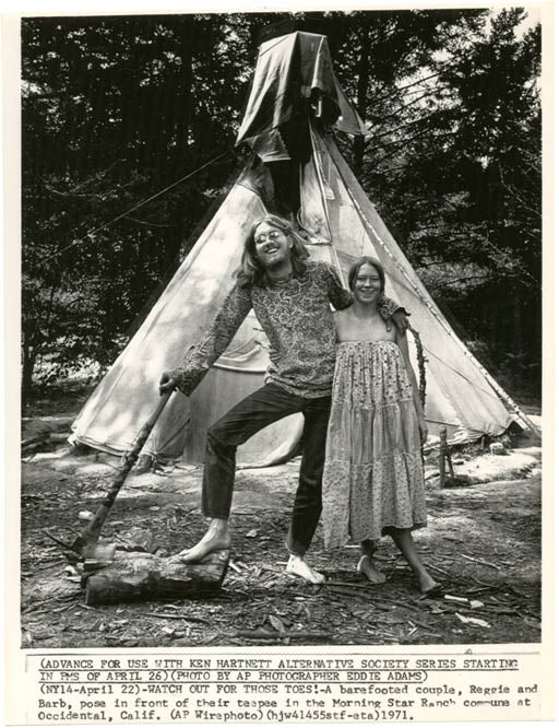 Item #39178 An original glossy b/w press photograph by Eddie Adams, with printed caption to lower edge: "Watch Out For Those Toes! - A barefooted couple, Reggie and Barb, pose in front of their teepee in the Morning Star Ranch commune at Occidental, Calif." (April 1971). MORNING STAR RANCH.