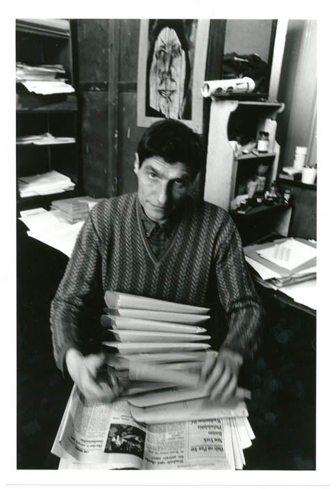Item #39344 An original b/w photograph by John Hopkins of Alexander Trocchi sitting at his desk in his flat at 6 St. Stephen's Gardens, Notting Hill, c. late 1964.