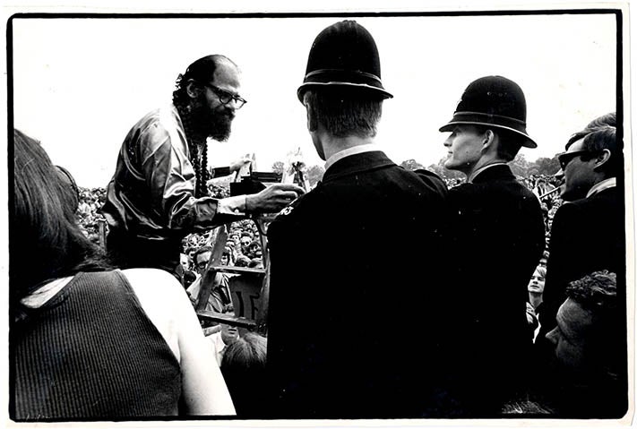 Item #39620 An original b/w photograph by Malcolm Hart capturing the moment Allen Ginsberg handed a flower to a policeman during the Legalise Pot Rally in Hyde Park on July 16, 1967. 1967 LEGALISE POT RALLY.