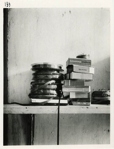 Item #40803 A b/w photograph by Harold Chapman of a collection of open reel tapes and tape boxes belonging to William Burroughs, stacked together on a shelf in his room at the Beat Hotel in Paris. William S. BURROUGHS.