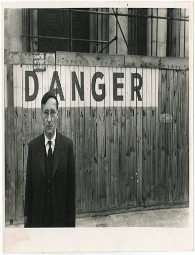 Item #41005 A b/w photograph of William Burroughs at the Place de l&rsquo;Od&eacute;on in 1959, with his back to a construction site wall stencilled with the word &lsquo;Danger&rsquo;. William S. BURROUGHS, Brion GYSIN.