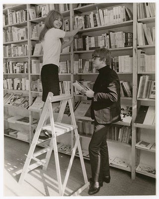 Item #41239 A b/w photograph by Graham Keen of Peter and Jane Asher shelving books at Indica, c....