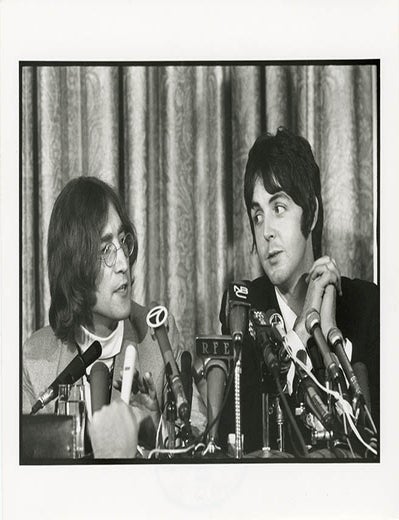 An original 8x10 photograph by Linda McCartney of John Lennon and Paul McCartney at a press. The BEATLES.